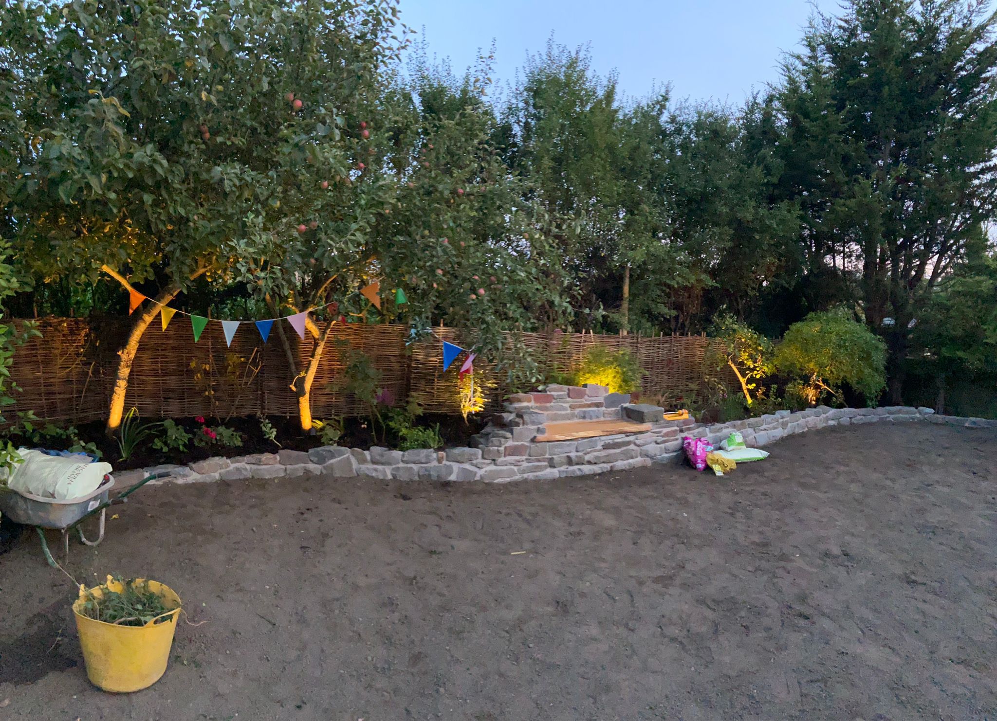 Garden stone wall with tree uplighting and bunting
