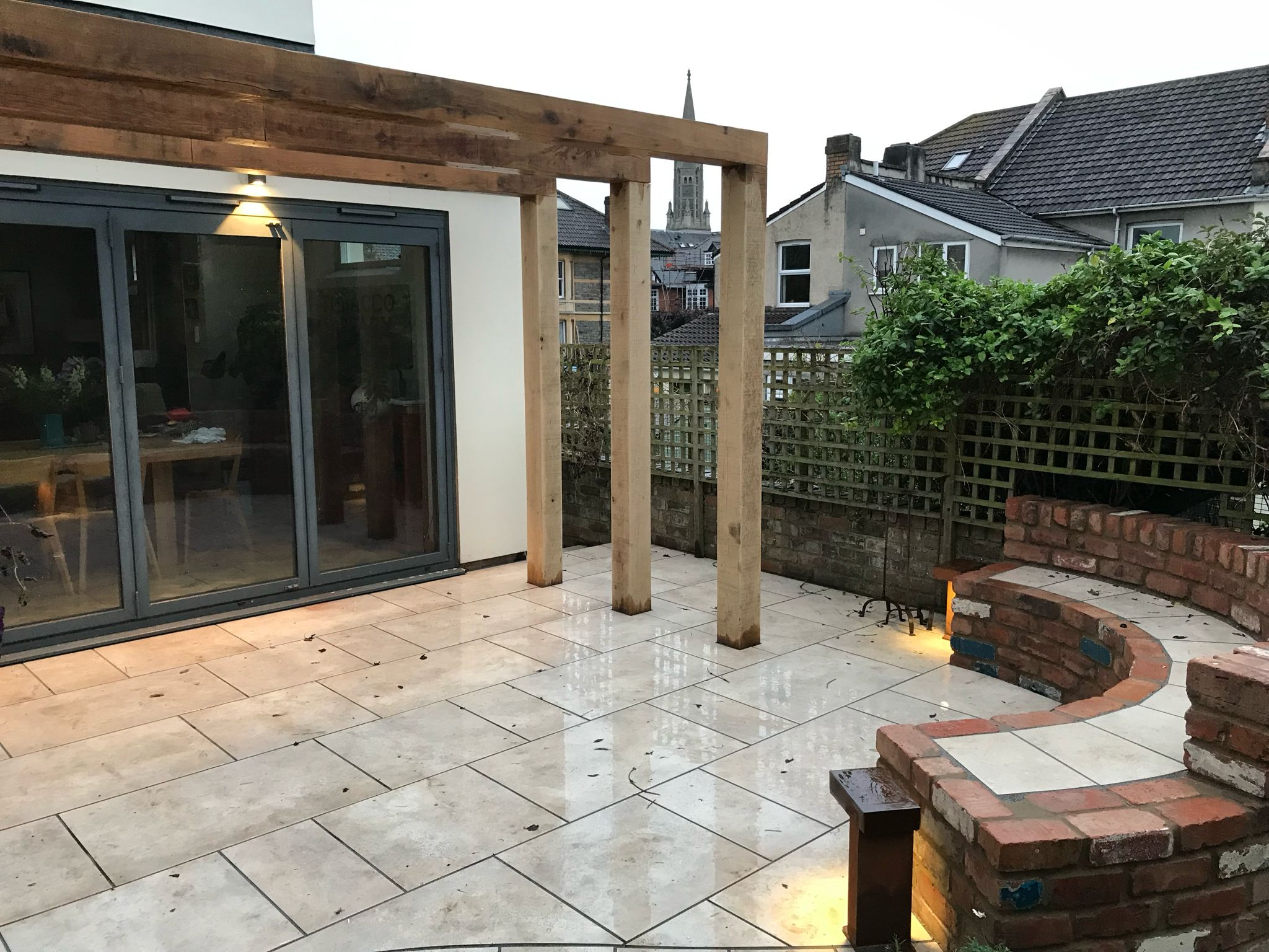 Timber pergola patio with brick seating and bollard lights