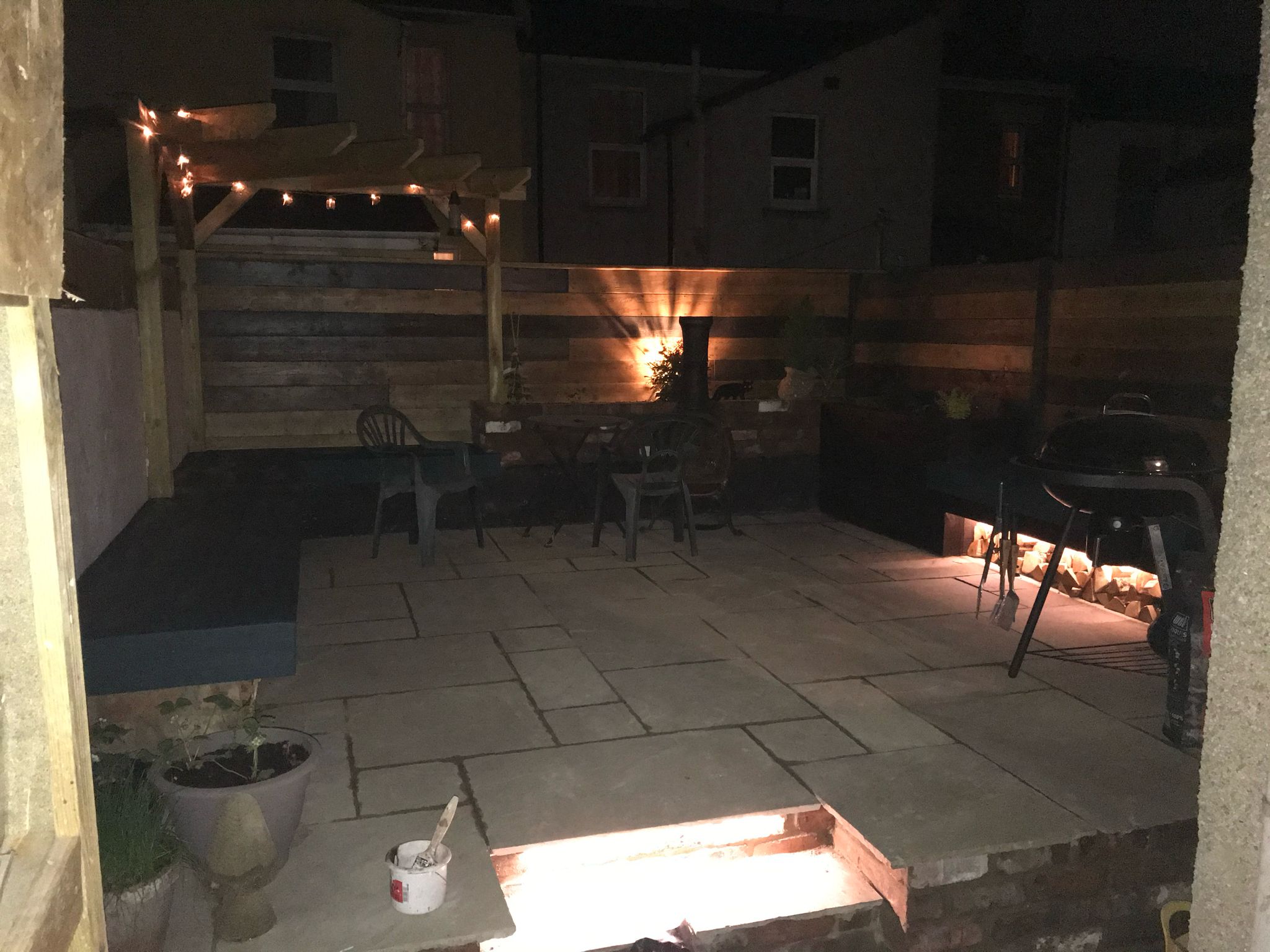 Patio with pergola festoon lights and ground-level lighting