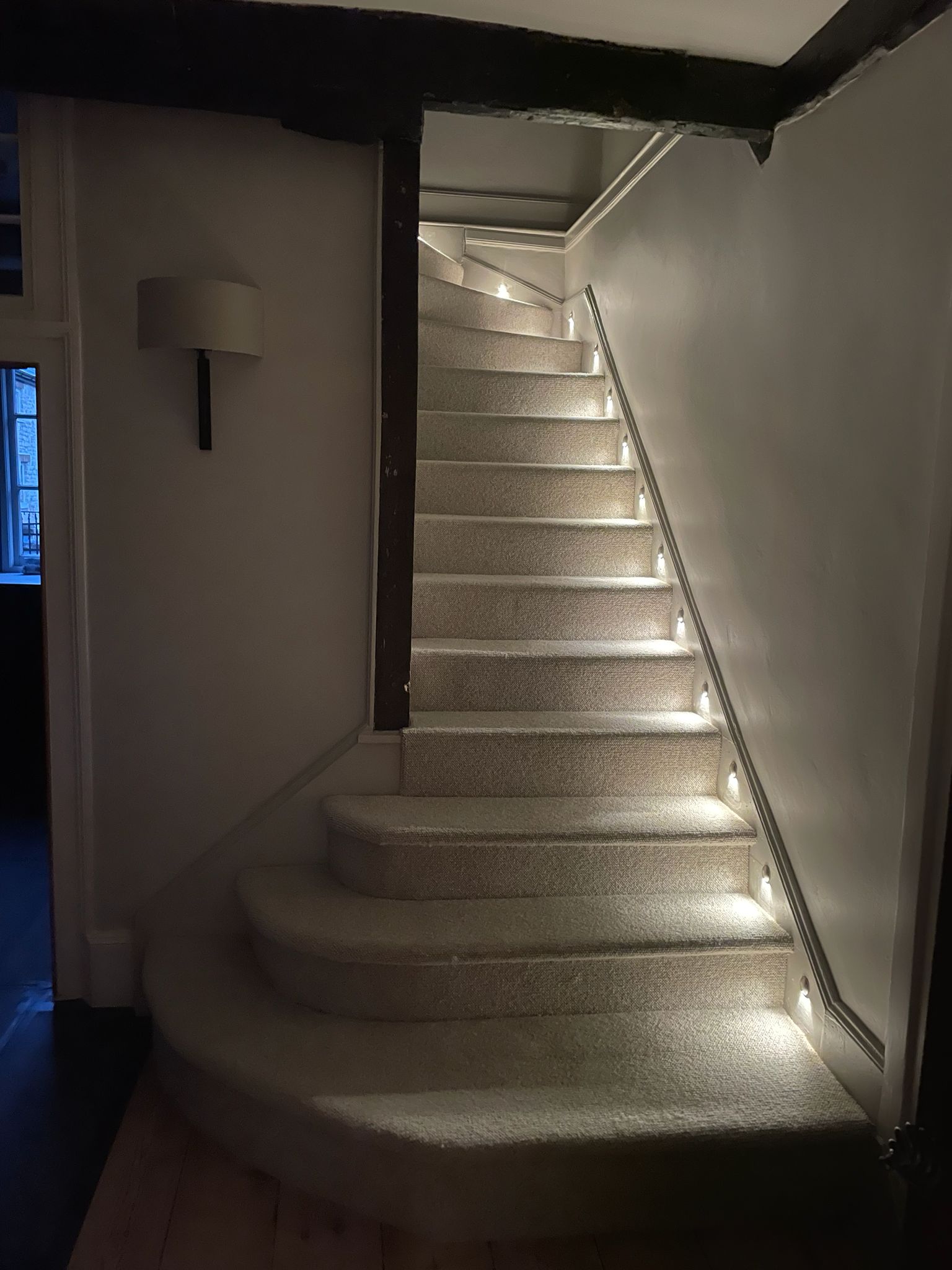 Staircase with LED strip lighting along edges and handrail