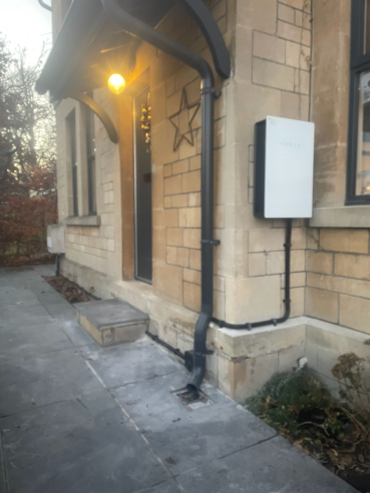 Tesla Powerwall mounted on exterior stone building