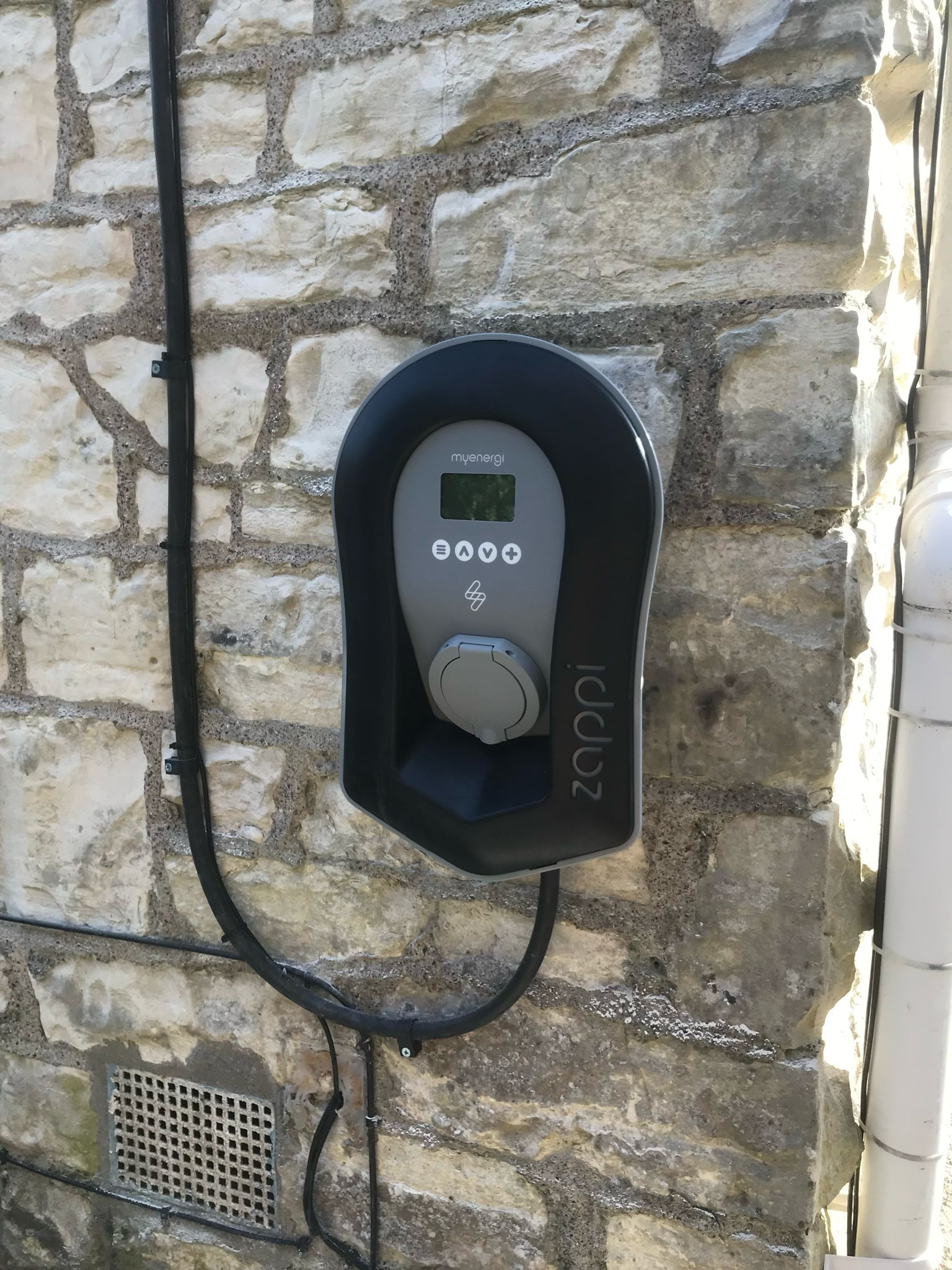 Myenergi Zappi EV charger installed on stone wall